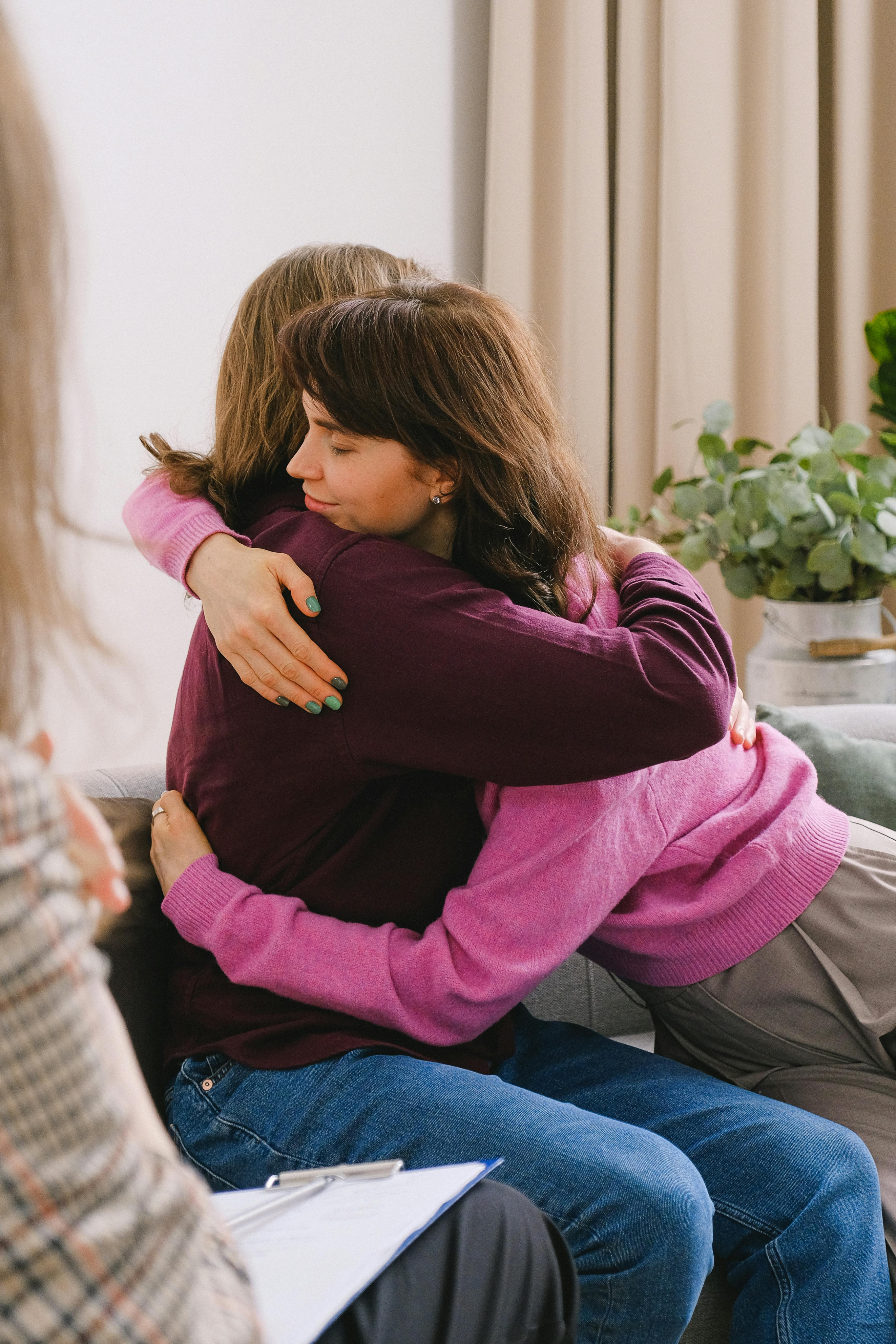A child hugging an adult in a quiet, comforting moment.