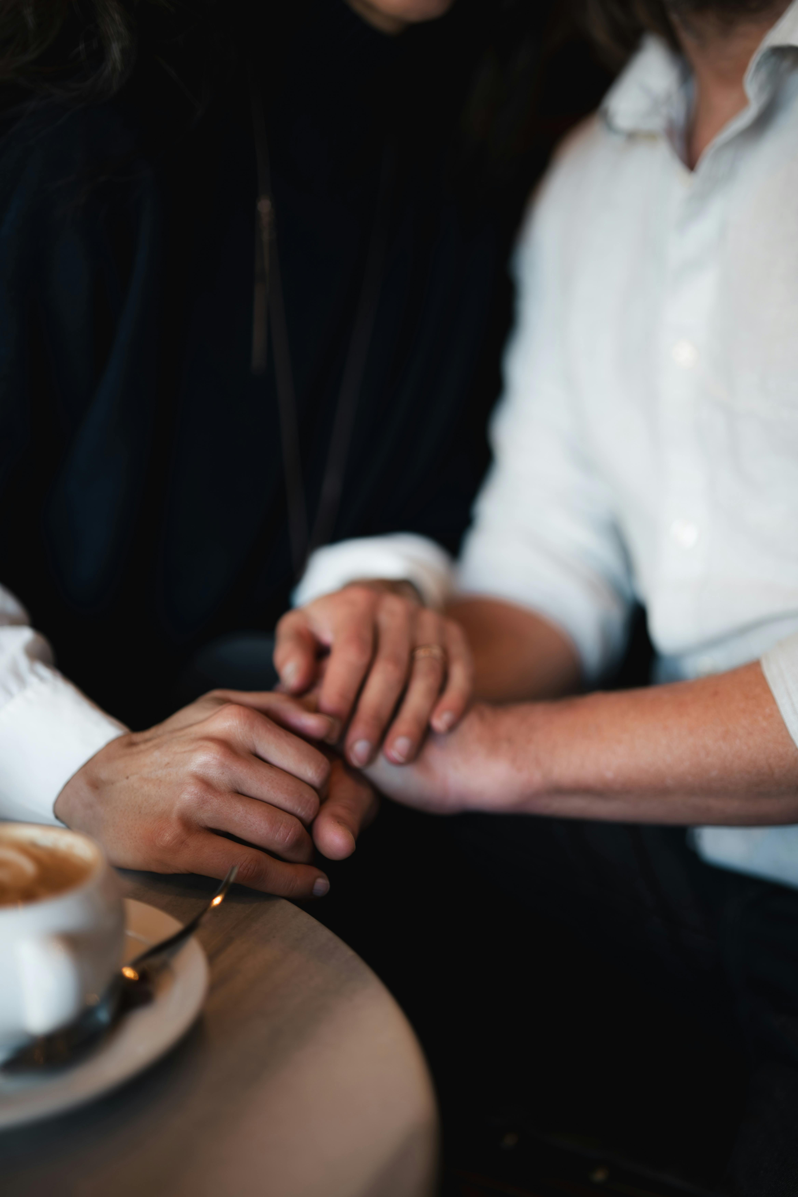 A close-up of hands held in support and comfort.